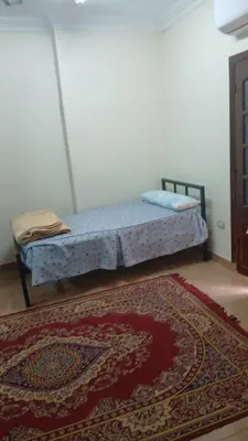 a bedroom with a bed and a rug on the floor at الاقصر امتداد ش التليفزيون in Al Bayāḑīyah