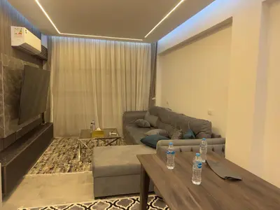 a living room with a couch and a table at Modern 2 Bedroom Apartment with Private Beach Hurghada in Hurghada