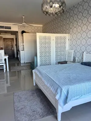 a bedroom with a white bed and a chandelier at Luxury Studio in Aldau Heights Hurghada in Hurghada