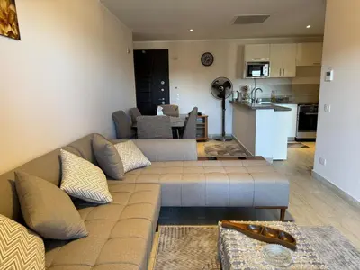a living room with a couch and a kitchen at Sun & Fun Aldau Heights one bedroom apartment in hurghada in Hurghada