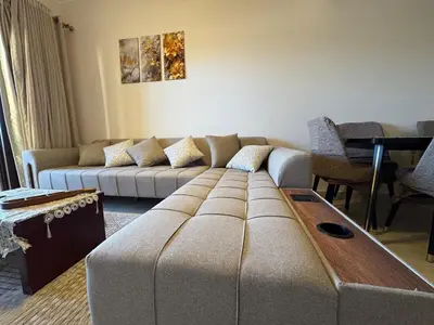 a living room with a couch and a table at Sun & Fun Aldau Heights one bedroom apartment in hurghada in Hurghada