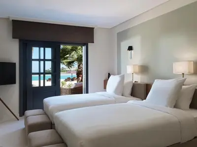 a hotel room with two beds and a television at The Chedi El Gouna in Hurghada
