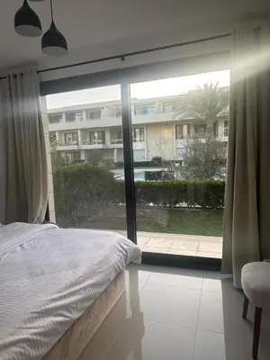 a bedroom with a bed and a large window at Hotel apartment in G cribs 2BR in El Gouna
