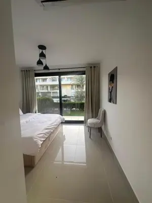 a bedroom with a bed and a chair and a window at Hotel apartment in G cribs 2BR in El Gouna