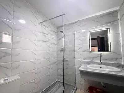 a white bathroom with a sink and a mirror at 2 bedrooms in Hurghada Hub Resort in Hurghada