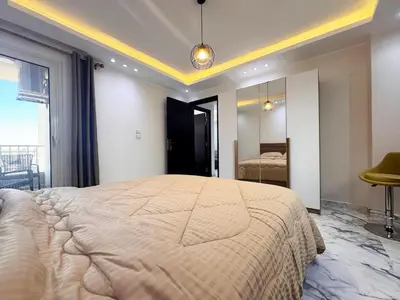 a bedroom with a large bed and a mirror at 2 bedrooms in Hurghada Hub Resort in Hurghada