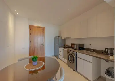 a kitchen with a table and a counter top at Brand-New 1BR in Kamaran El Gouna I Pool View & Access in Hurghada