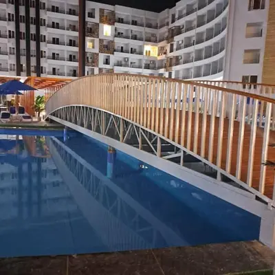 a bridge over a swimming pool next to a building at Taiba Golden Resort in Hurghada