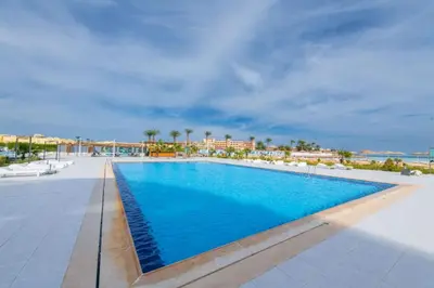 a swimming pool at a resort with blue water at scandic Resort hurghada in Hurghada