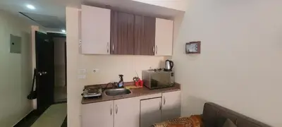 a small kitchen with white cabinets and a sink at Apartment With Free Private Beach Furnished Near senzomall in Hurghada