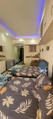 two beds in a room with a kitchen at Apartment With Free Private Beach Furnished Near senzomall in Hurghada