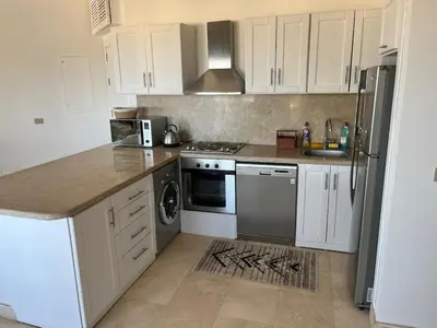 a kitchen with white cabinets and a stove top oven at Seaview Apartment in Azzurra Sahl Hasheesh 2 bedrooms in Hurghada