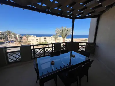 a table on a balcony with a view of the ocean at Seaview Apartment in Azzurra Sahl Hasheesh 2 bedrooms in Hurghada