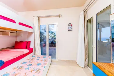 a bedroom with a bunk bed and a balcony at Apartment Azzura Sahl Hasheesh with Private Garden and Sea view in Hurghada