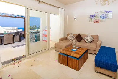a living room with a couch and a table at Apartment Azzura Sahl Hasheesh with Private Garden and Sea view in Hurghada
