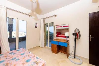 a bedroom with a bed and a desk and a window at Apartment Azzura Sahl Hasheesh with Private Garden and Sea view in Hurghada