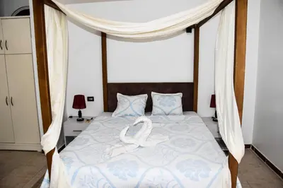 a bedroom with a bed with two swans on it at Villa Acamar in Al Karnak