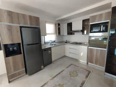 a kitchen with stainless steel appliances and wooden cabinets at The View Island in Hurghada