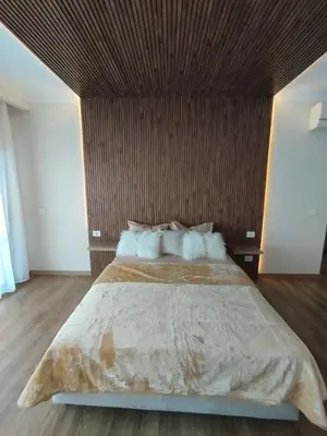a bedroom with a large bed with a wooden headboard at The View Island in Hurghada