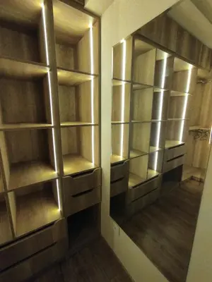 a walk in closet with wooden shelves and a mirror at The View Island in Hurghada