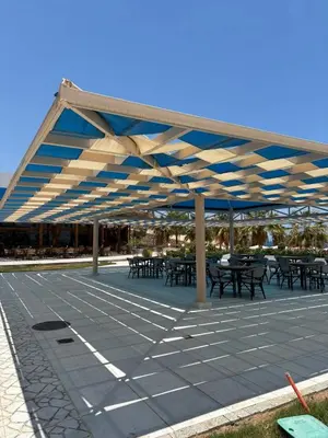 a patio with tables and chairs under a blue and white canopy at The View Island in Hurghada