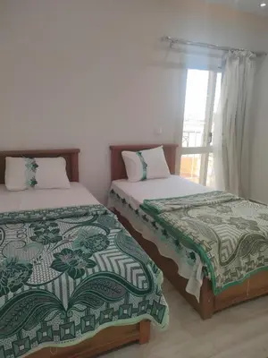 two beds sitting next to each other in a room at red ruby Comfort in Hurghada
