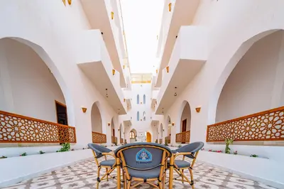 a courtyard with chairs and a table in a building at El Bawaba Lodge & Luxury Retreat in Al Aqālitah