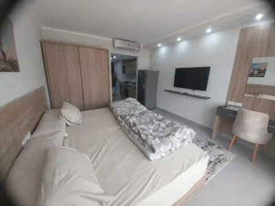 a bedroom with a large bed and a television at pola studio at scandic resort in Hurghada