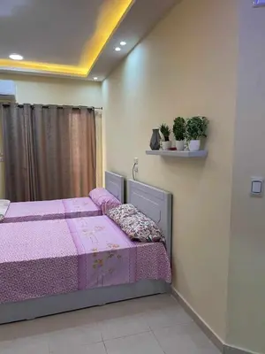 a bedroom with a bed with a purple comforter at Studio in Hurghada