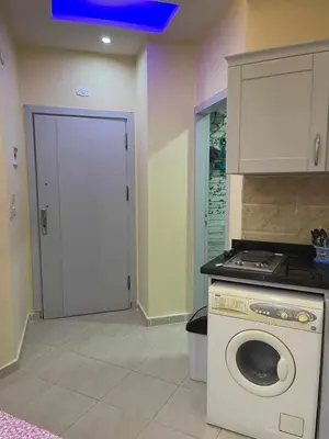 a kitchen with a washing machine and a door at Studio in Hurghada