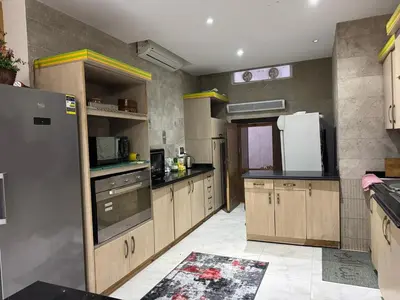 a large kitchen with wooden cabinets and a refrigerator at Villa 348 Jamaran - Sahl Hasheesh in Hurghada