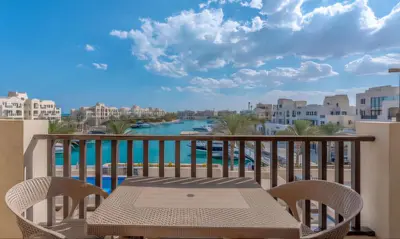 a balcony with a table and chairs and a view of the water at Luxury Stays in Fanadir Marina El Gouna in Hurghada