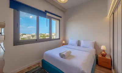 a bedroom with a large white bed with a window at Luxury Stays in Fanadir Marina El Gouna in Hurghada