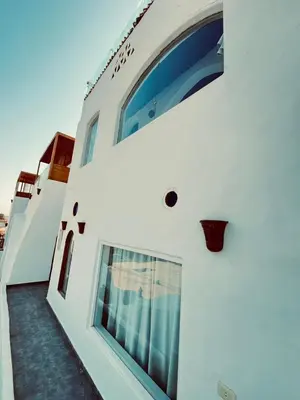 a white building with windows on the side of it at nubiary in Jazīrat Salūjah