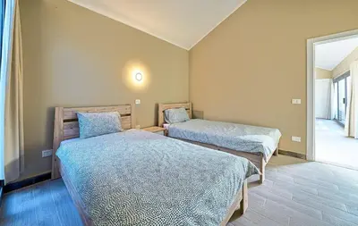 a bedroom with two beds and a mirror at Bali 2 BR private pool el gouna heated pool in Hurghada