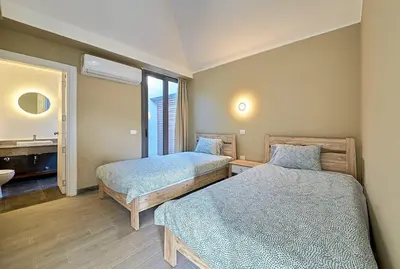 a bedroom with two beds and a bathroom with a sink at Bali 2 BR private pool el gouna heated pool in Hurghada