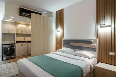 a bedroom with a large bed and a kitchen at Al Saraya Sahl Hasheesh by Peaks Studio with Pool View C106 in Hurghada
