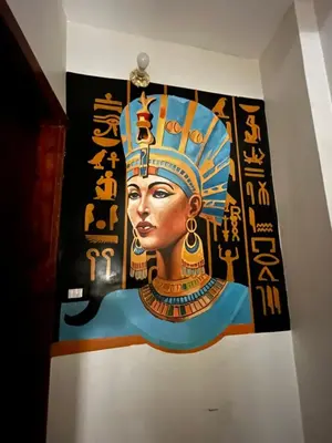 a painting of a woman on a wall at Al FAHAD private apartments for rent in Luxor