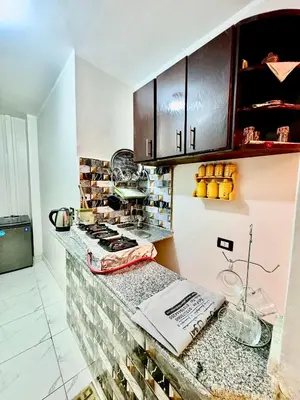a kitchen with a counter with a stove and cabinets at Al FAHAD private apartments for rent in Luxor
