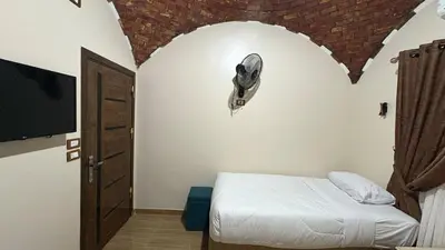 a bedroom with a bed and a hat on the wall at Lilys Garden Guest House in Jazīrat al ‘Awwāmīyah