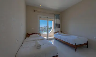 a bedroom with two beds and a window with a balcony at Luxury Villas in Joubal El Gouna in Hurghada