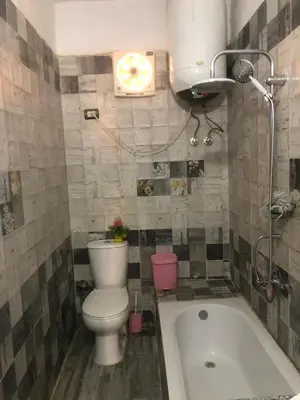 a bathroom with a toilet and a bath tub at HAWATY NUBA DWeLL in Nag` el-Ramla