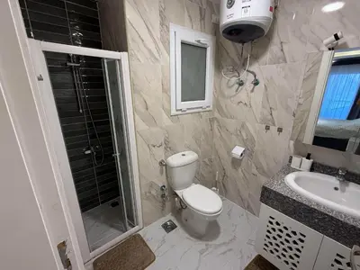 a bathroom with a toilet and a sink and a shower at Luxury Selena Bay Apartment- Private Beach, Kite School 5 Pools in Hurghada