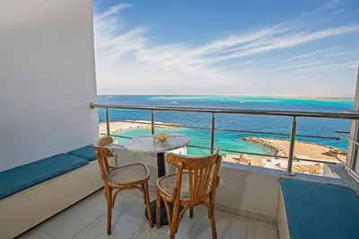 a balcony with a table and chairs and the ocean at Amazing 2 bedroom apartment with sea view in Hurghada in Hurghada