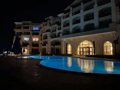 a swimming pool in front of a building at night at Luxury Apartment In The View in Hurghada