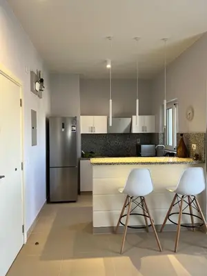 a kitchen with two white chairs and a counter at El Gouna 1 Bedroom Waterside in Hurghada
