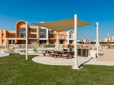 a picnic shelter with a picnic table in the grass at Kamaran 2BR • Luxurious Retreat in Hurghada