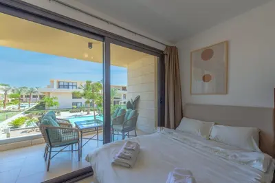 a bedroom with a bed and a balcony with a pool at The Contemporary Condo in Gouna in Hurghada
