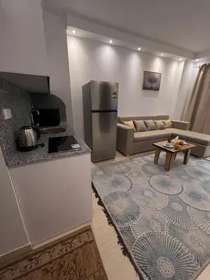 a kitchen with a refrigerator and a living room at Luxury One Bed Room Apartment in Hurghada