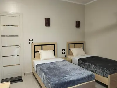 a bedroom with two beds and a door sidx sidx sidx sidx at Rayan Nubian Guest House in Aswan